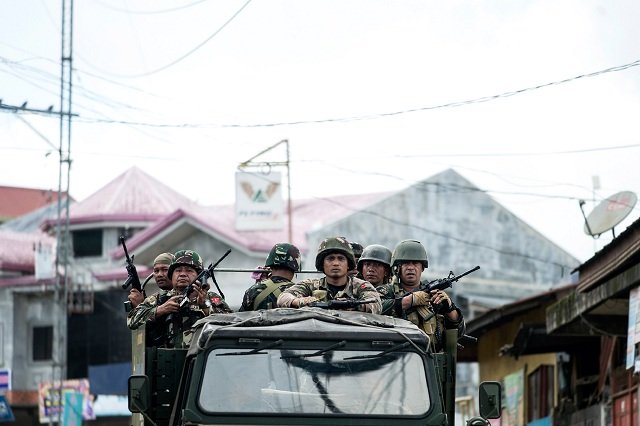 soldiers aboard a vehicle manoeuvre through a street in marawi on the southern island of mindanao on june 14 2017 photo afp