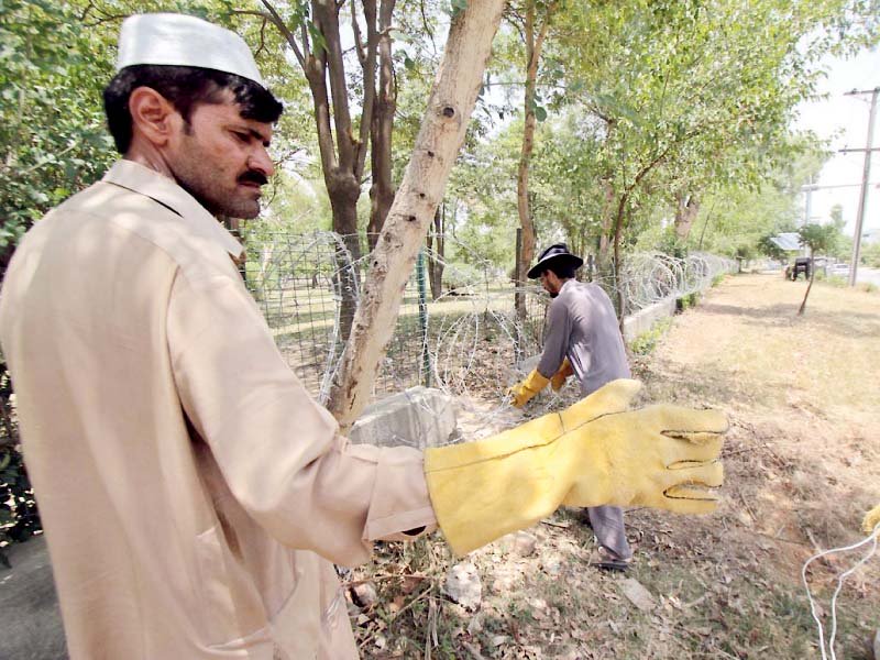 workers install barbed wire around the federal judicial academy ahead of pm s visit photo online