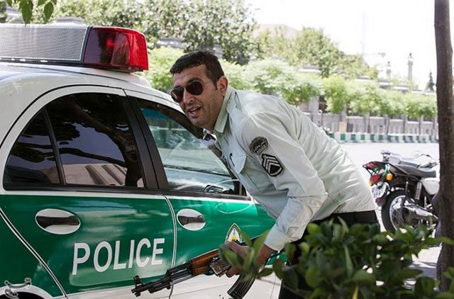 an iranian policeman takes cover during an attack on the iranian parliament in central tehran photo reuters