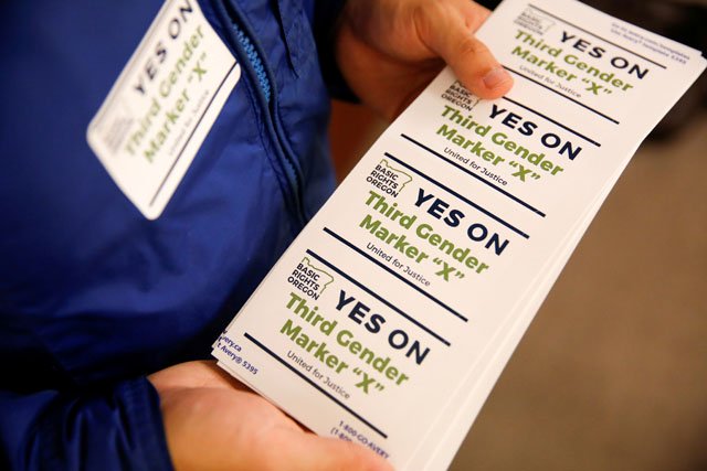 an employee of the advocacy group basic rights oregon hands out stickers during an oregon driver and motor vehicle department public hearing on the rights of transgender people as the state considers adding a third gender choice to driver 039 s licenses and identification cards in portland oregon may 10 2017 photo reuters
