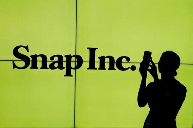 file photo a woman stands in front of the logo of snap inc on the floor of the new york stock exchange nyse while waiting for snap inc to post their ipo in new york city new york u s on march 2 2017 photo reuters