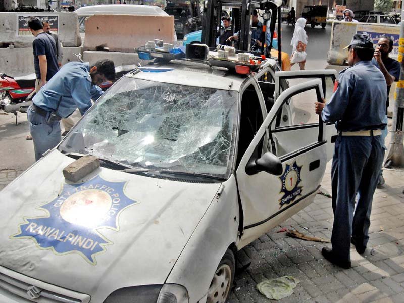 policemen inspect a squad car damaged by bikers who had attacked the checkpost in chandni chowk after an anti wheeling operation by the police photo nni