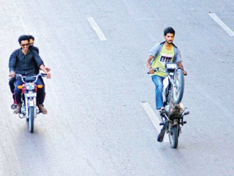 a rider one wheels on his motorbike on benazir bhutto shaheed road near new town police station photo waseem imran express