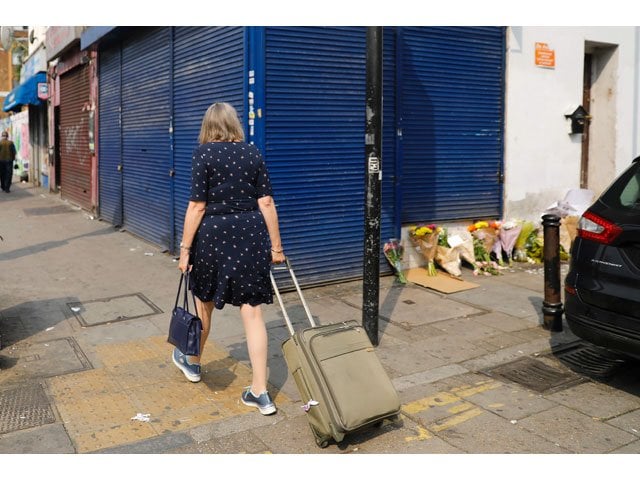 a woman looks at tributes and flowers left at the scene of the june 19 van attack on pedestrians in the finsbury park area of north london on june 20 2017 photo afp