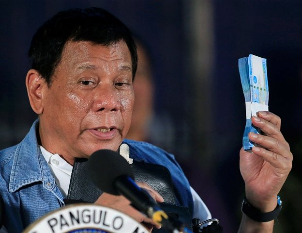 philippines 039 president rodrigo duterte holds philippine peso bills for the marawi evacuees during his visit at the iligan city national school of fisheries evacuation center in iligan city philippines june 20 2017 photo reuters