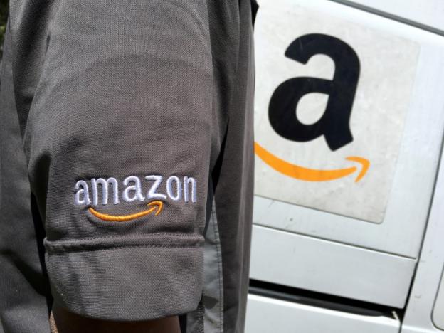 file photo an amazon com inc driver stands next to an amazon delivery truck in los angeles california u s on may 21 2016 photo reuters