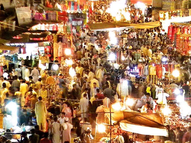 rush of buyers in a bazaar and a worker sets dresses at his shop photo agencies