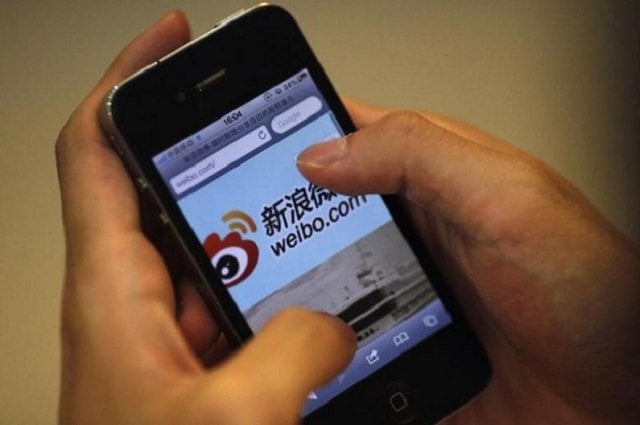 a man holds an iphone as he visits sina 039 s weibo microblogging site in shanghai may 29 2012 photo reuters