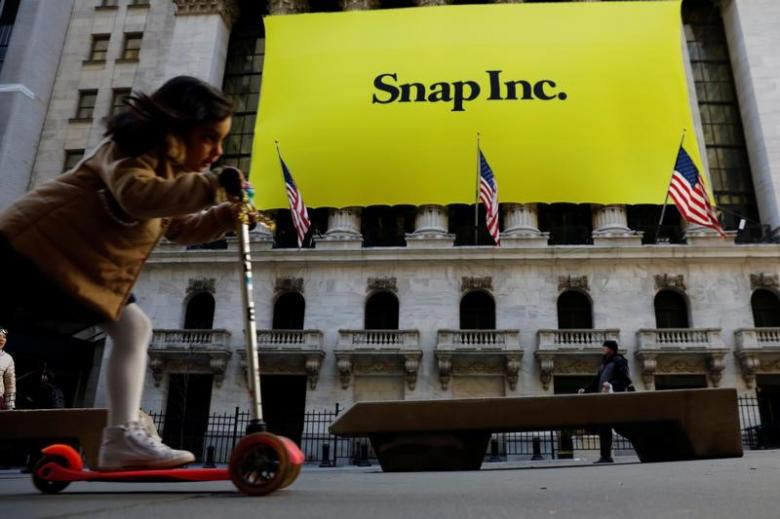 a young girl pushes her scooter past the front of the new york stock exchange nyse with a snap inc logo hung on the front of it shortly before the company 039 s ipo in new york us march 2 2017 photo reuters