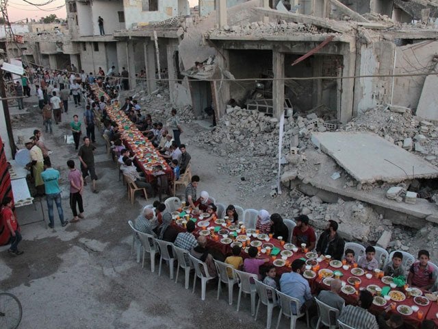 residents of douma can be seen breaking their fast as a symbol of resilience in the face of death and destruction photo afp