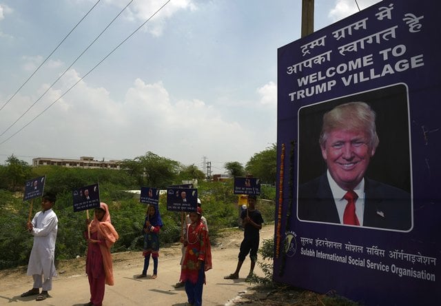 indian children hold placards by the entrance gate of marora village which has been unofficially renamed 039 trump village quot about 100km from new delhi on june 23 2017 photo afp