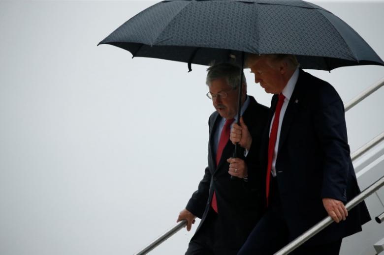 us president donald trump r holds an umbrella over us ambassador to china terry branstad former governor of iowa as they arrive together aboard air force one at eastern iowa airport in cedar rapids iowa us june 21 2017 photo reuters