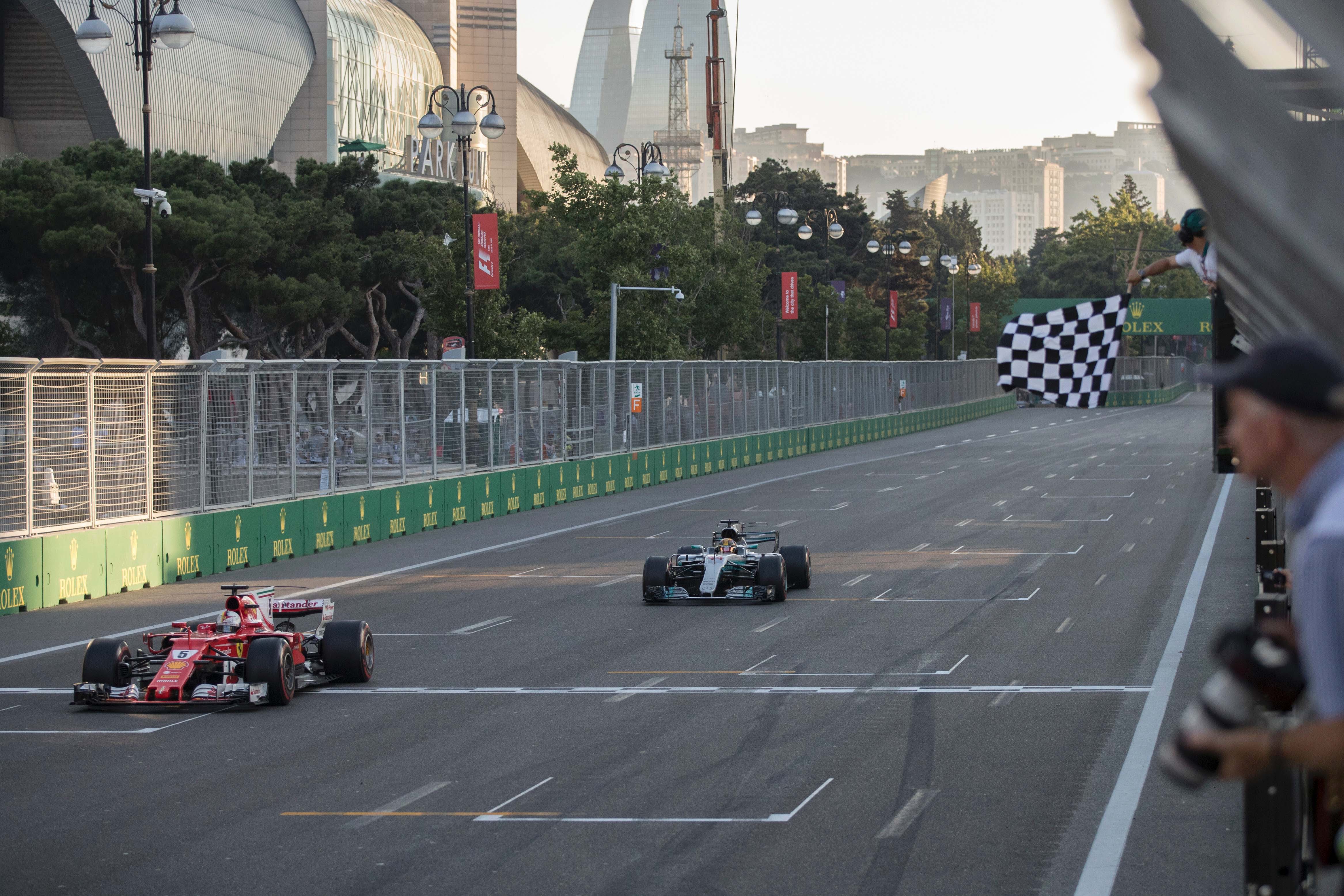 ferrari 039 s german driver sebastian vettel crosses the finish line ahead of mercedes 039 british driver lewis hamilton during the formula one azerbaijan grand prix at the baku city circuit photo afp