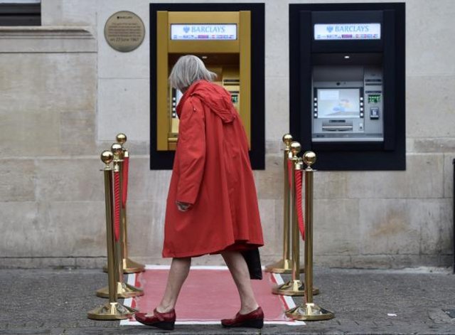 a woman walks past a golden atm marking the location of the first 039 hole in the wall 039 which opened fifty years ago in enfield britain june 27 2017 photo reuters