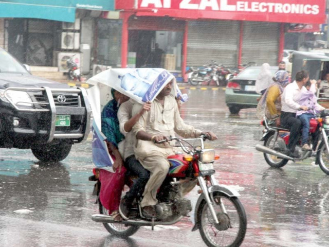 bikers take shelter from the rain under a panaflex photo abid nawaz express bikers take shelter from the rain under a panaflex photo abid nawaz express