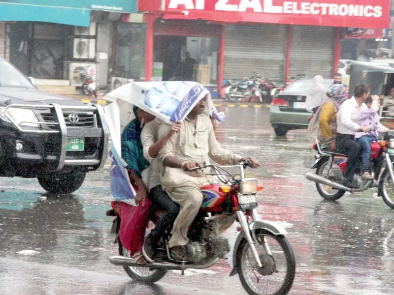 bikers take shelter from the rain under a panaflex photo abid nawaz express bikers take shelter from the rain under a panaflex photo abid nawaz express