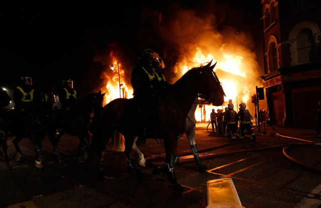 mounted police ride in front of a burning building in tottenham north london on august 7 2011 photo reuters mounted police ride in front of a burning building in tottenham north london on august 7 2011 photo reuters