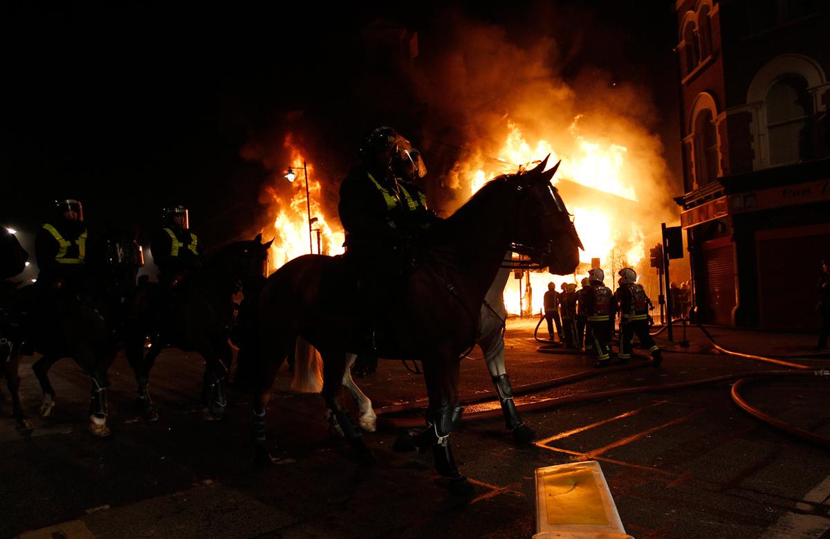 mounted police ride in front of a burning building in tottenham north london on august 7 2011 photo reuters