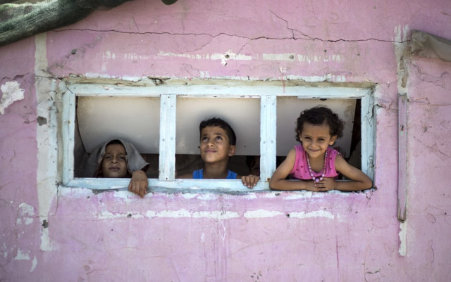 palestinian children are seen looking outside a window during a heatwave at al shati refugee camp in gaza city photo afp