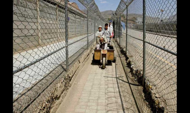 men coming from afghanistan move down a corridor between security fences at the border post in torkham pakistan on the durand line on 18 june 2016 photo reuters men coming from afghanistan move down a corridor between security fences at the border post in torkham pakistan on the durand line on 18 june 2016 photo reuters