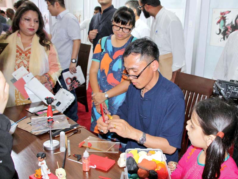 a chinese artist moulds dough at an exhibition of dalian jinpuu new area featuring different kinds of artwork of the region photo online