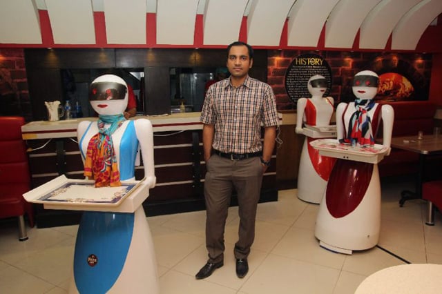 in this photograph taken on july 4 2017 pakistani engineer osama jafari c poses with robot waitresses annie l rabia r and jennie background at his pizza restaurant in multan photo afp