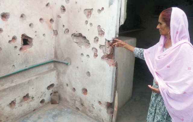 an old woman shows her house damaged by indian shelling photo inp an old woman shows her house damaged by indian shelling photo inp