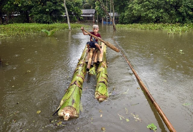 a boy rows a makeshift raft outside his submerged house in the flood affected kuthori village near kaziranga national park in nagaon district in the northeastern state of assam india july 11 2017 photo reuters a boy rows a makeshift raft outside his submerged house in the flood affected kuthori village near kaziranga national park in nagaon district in the northeastern state of assam india july 11 2017 photo reuters