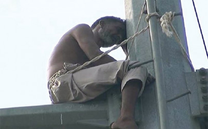 man climbs electric pole to register protest