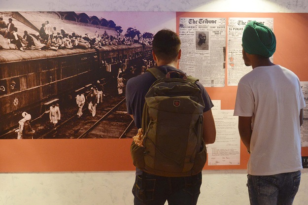 visitors look at photographs and newspaper clippings at the partition museum in amritsar india photo afp