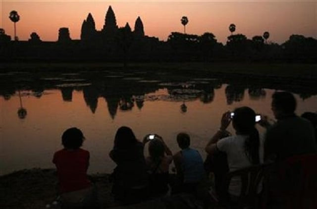 tourists take photos of the sunrise over angkor wat in siem reap photo reuters tourists take photos of the sunrise over angkor wat in siem reap photo reuters