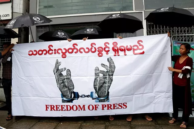 journalists hold a banner as they protest against a law they say curbs free speech at the start of a trial of two journalists who the army is suing for defamation over a satirical article in yangon myanmar june 8 2017 photo reuters