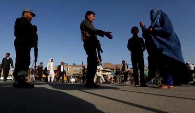 an afghan family waits as policemen block the road near the site of of suicide bomb attack in kabul afghanistan april 12 2017 photo reuters