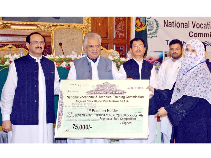 k p governor engr iqbal zafar jhagra awards a cheque to 1st position holder at navttc skills competition at governor s house photo inp