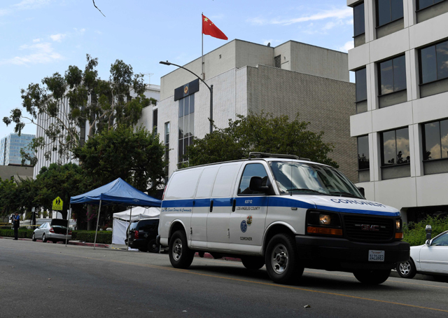 staff from the coroners office remove the body from the front of the chinese consulate r after a man of chinese descent fired several shots at the consulate building then committed suicide near its entrance in los angeles california photo afp