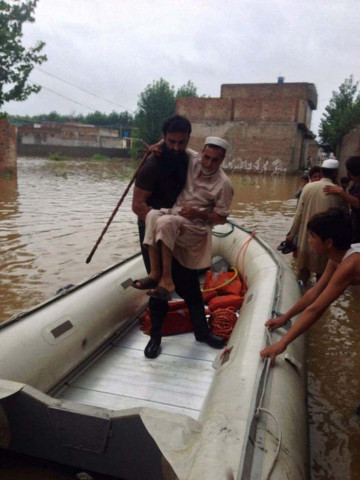a rescue 1122 official helps a man into a rescue boat in flooded charsadda photo rescue 1122 a rescue 1122 official helps a man into a rescue boat in flooded charsadda photo rescue 1122