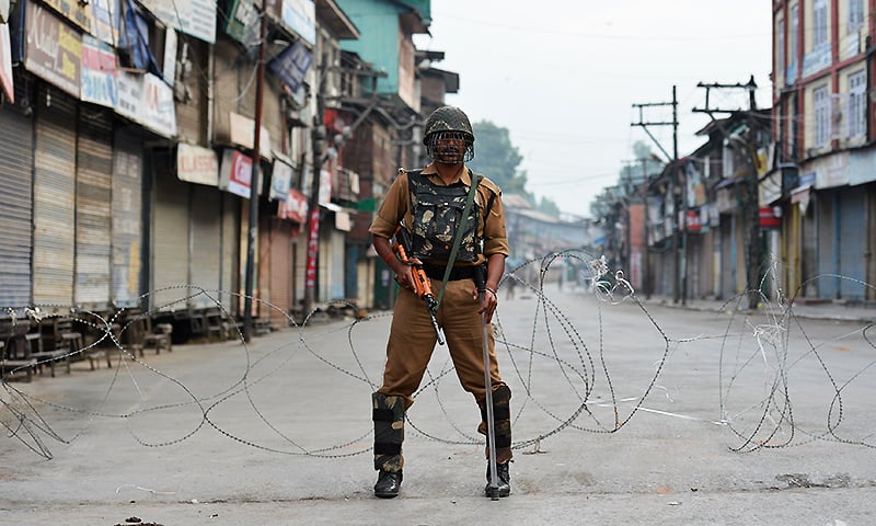 an indian paramilitary troop stands guard during a curfew in srinagar photo afp