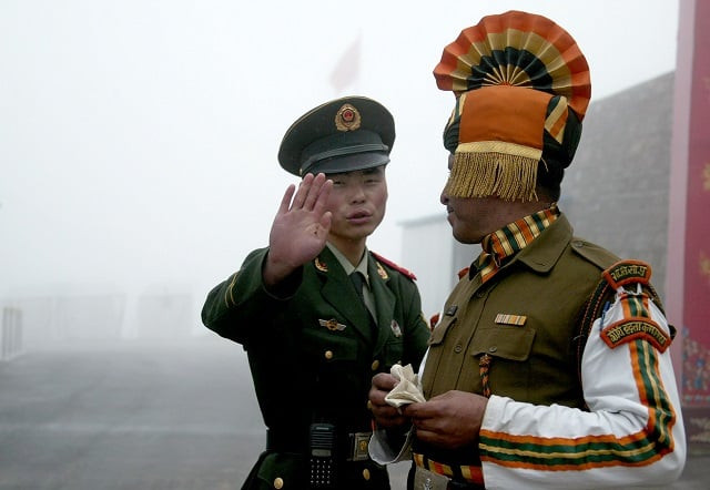 this file photo taken on july 10 2008 shows a chinese soldier l gesturing next to an indian soldier at the nathu la border crossing between india and china in india 039 s northeastern sikkim state china has stepped up its rhetoric in an increasingly tense border row with india hinting at the possibility of military action in a propaganda push that analysts are calling quot genuinely troubling quot for more than a month indian and chinese troops have been locked in a standoff on a remote but strategically important himalayan plateau near where tibet india and bhutan meet photo afp