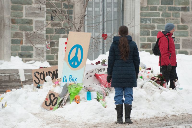 people visit a makeshift memorial near a quebec mosque where six people were killed in a shooting spree in january photo afp