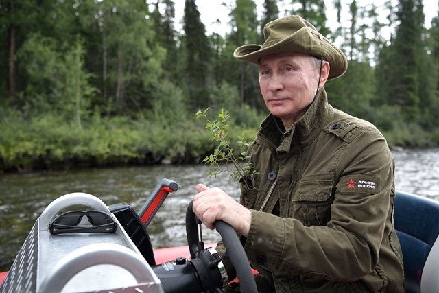 russian president vladimir putin guides a boat during his vacation the remote tuva region in southern siberia the picture taken between august 1 and 3 2017 photo afp