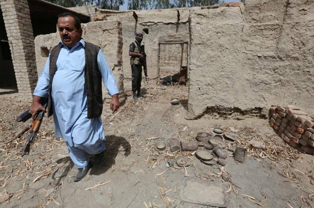 a policeman in plain clothes l walks out of a damaged house which witnesses said belonged to hafeez brohi wanted in connection with bombings in shikarpur and suspected in many other blasts in sindh province photo reuters