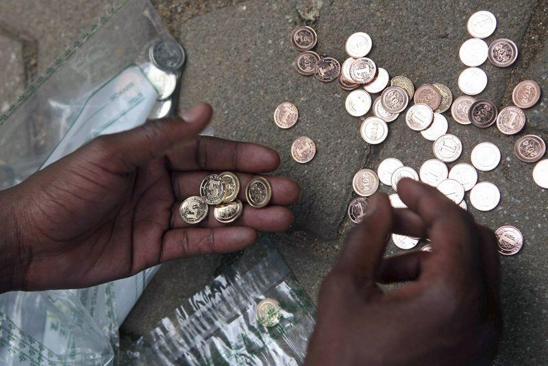 a zimbabwean street vendor sorts new coins in front of a bank photo reuters