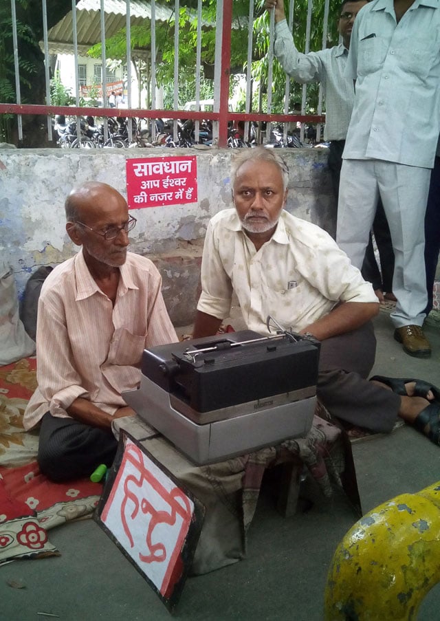 indian street typist kishan kumar l poses with an unidentified man r and his new typewriter on a street in lucknow on september 22 2015 photo afp