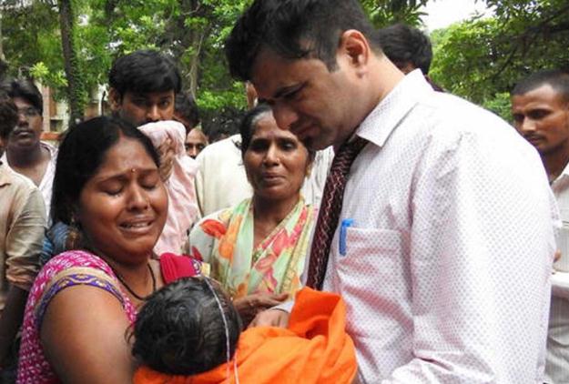 a woman carries a child at the baba raghav das hospital in gorakhpur india photo courtesy la times
