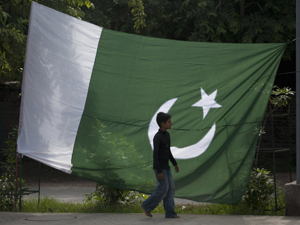 a boy walks past a pakistani flag displayed for sale ahead of pakistan 039 s independence day along a road in rawalpindi photo reuters