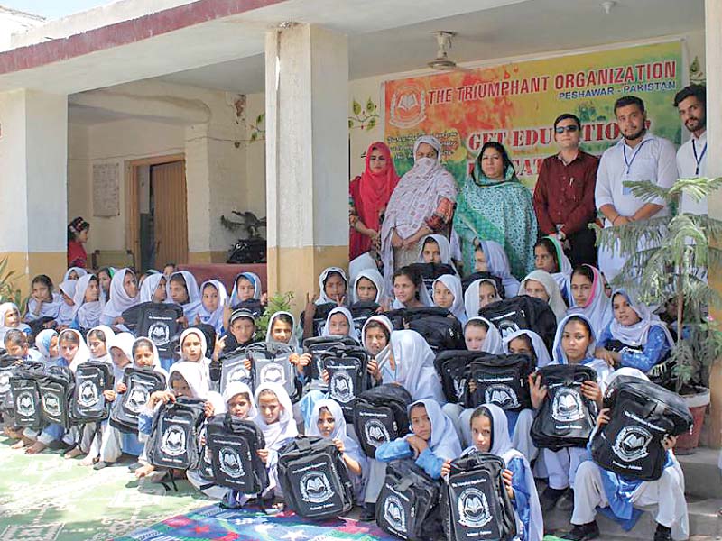 students holding bags distributed by the triumphiant organisation in peshawar photo express