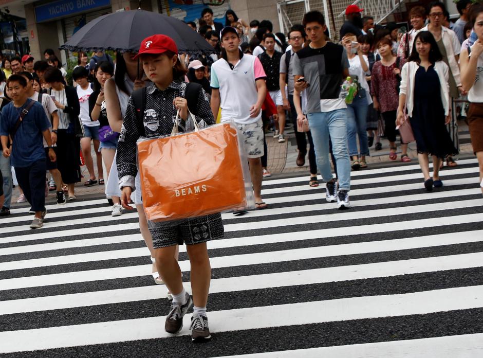 a woman carries a shopping bag at a shopping district in tokyo japan photo reuters