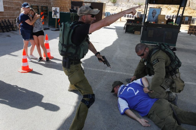 foreign tourists react as isreali instructors tackle a man during a simulation knife attack photo afp foreign tourists react as isreali instructors tackle a man during a simulation knife attack photo afp