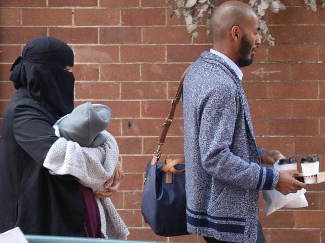 the muslim woman was wearing a headscarf and veil when she and her husband saw her staring at the photo courtesy the daily telegraph