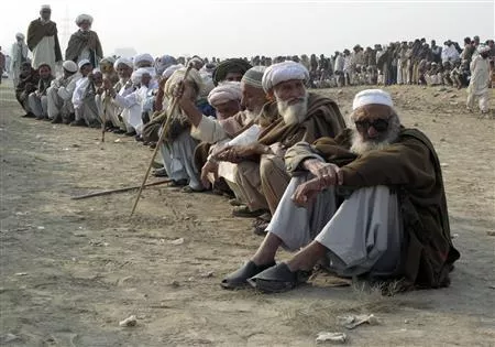 men fleeing a military offensive in south waziristan line up while waiting for their turn to collect handouts at a distribution point for idps in dera ismail khan photo reuters